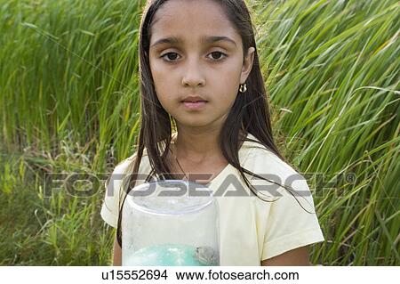 8 year old girl in wetland holding frog in collecting jar, Winnipeg, Canada View Large Photo Image Picture - 8 year old girl in wetland holding frog in collecting jar, Winnipeg, Canada. Fotosearch