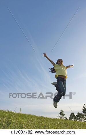 Stock Image - 8 year old girl jumping, Winnipeg, Canada. Fotosearch