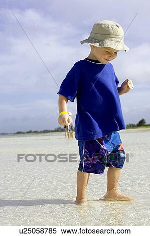 Boy standing in shallow water on beach, Camagüey, Cuba View Large Photo Image Stock Photography - Boy standing in shallow water on beach, Camagüey, Cuba. Fotosearch