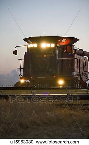 Combine with lights on working at night, Saskatchewan View Large Photo Image Stock Image - Combine with lights on working at night, Saskatchewan. Fotosearch
