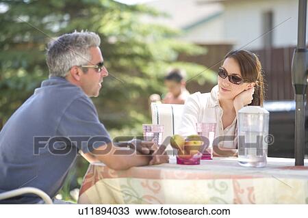 Couple seated at outdoor table, with water jug, Winnipeg, Canada View Large Photo Image Stock Image - Couple seated at outdoor table, with water jug, Winnipeg, Canada. Fotosearch