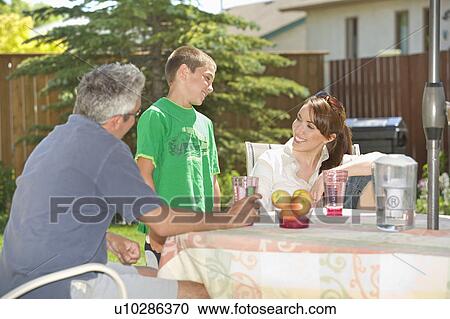 Couple speak with son at outdoor table, Winnipeg, Canada View Large Photo Image Stock Image - Couple speak with son at outdoor table, Winnipeg, Canada. Fotosearch