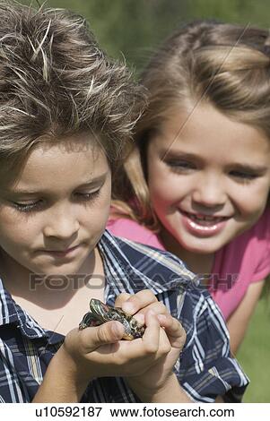 Stock Photo - Eight year old boy and six year old girl with turtle, Winnipeg, Canada. Fotosearch