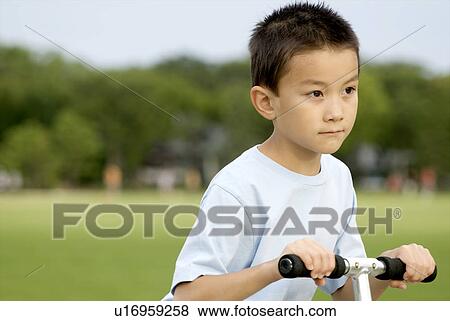 Stock Photo - Eight year old boy on scooter, Winnipeg, Canada. Fotosearch