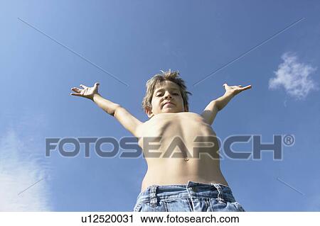 Stock Image - Eight year old boy with arms outstretched, Winnipeg, Canada. Fotosearch