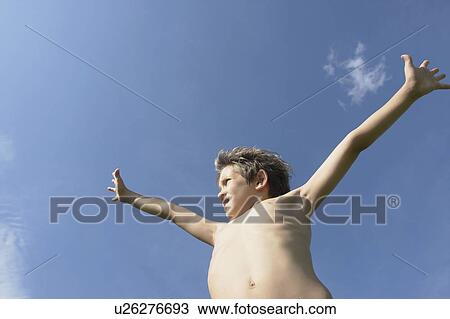 Stock Image - Eight year old boy with arms outstretched, Winnipeg, Canada. Fotosearch