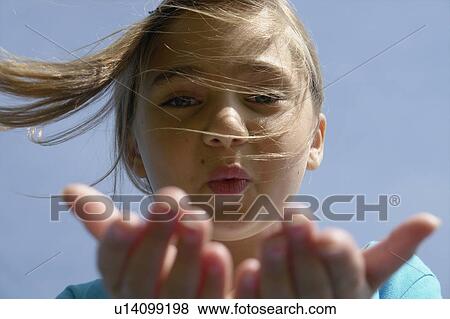 Eight year old girl blowing toward camera, Winnipeg, Canada View Large Photo Image Stock Photo - Eight year old girl blowing toward camera, Winnipeg, Canada. Fotosearch
