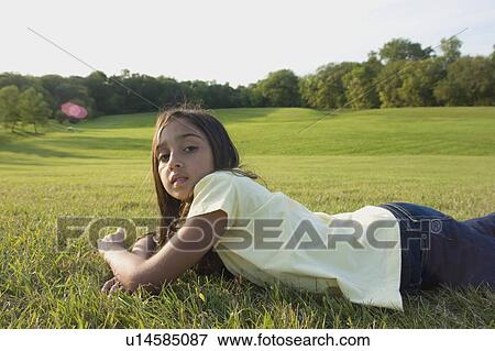 Eight year old girl laying down on grass in park, Winnipeg, Canada View Large Photo Image Stock Photo - Eight year old girl laying down on grass in park, Winnipeg, Canada. Fotosearch