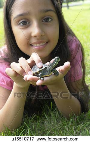 Eight year old girl lying in grass with turtle, Winnipeg, Canada View Large Photo Image Stock Photo - Eight year old girl lying in grass with turtle, Winnipeg, Canada. Fotosearch