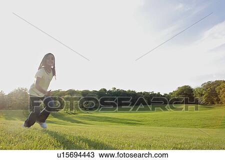 Stock Image - Eight year old girl running in park, Winnipeg, Canada. Fotosearch