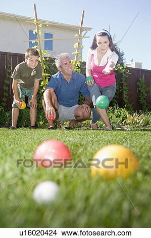 Picture - Family play bocce ball in backyard, Winnipeg, Canada. Fotosearch