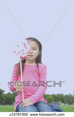 Stock Image - Five year old girl in park with pin wheel, Winnipeg, Canada. Fotosearch