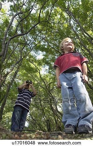 Stock Photo - Four and six year old brothers on walking trail in forest, Winnipeg, Canada. Fotosearch