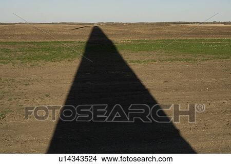 Picture - Long shadow of wind turbine on ground. Fotosearch