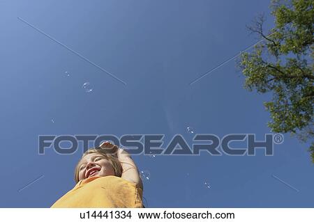 Low angle six year old girl, with bubbles, Winnipeg, Canada View Large Photo Image Picture - Low angle six year old girl, with bubbles, Winnipeg, Canada. Fotosearch