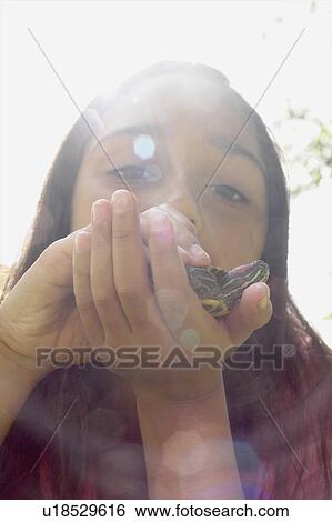 Stock Photograph - Low angle view, eight year old girl lying in grass with turtle, Winnipeg, Canada. Fotosearch