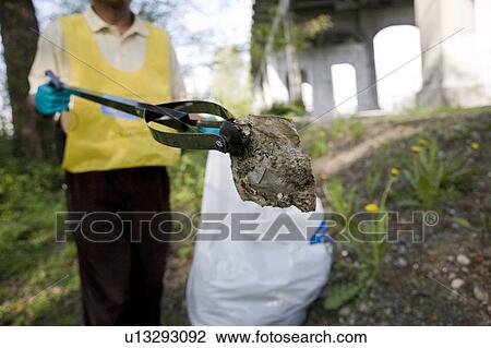 Stock Image - Man Cleaning up under Bridge, Vancouver, Canada. Fotosearch