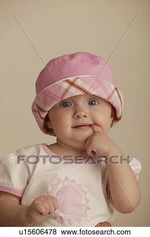 Stock Photo - Portrait of toddler with finger in her mouth, Regina, Saskatchewan. Fotosearch