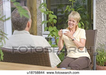 Picture - Senior couple enjoying coffee on deck, Winnipeg, Canada. Fotosearch