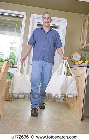 Senior man carrying groceries in cloth bags, Winnipeg, Canada View Large Photo Image Stock Image - Senior man carrying groceries in cloth bags, Winnipeg, Canada. Fotosearch