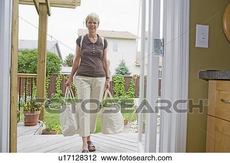Senior woman carries cloth grocery bags into kitchen, Winnipeg, Canada View Large Photo Image Stock Image - Senior woman carries cloth grocery bags into kitchen, Winnipeg, Canada. Fotosearch