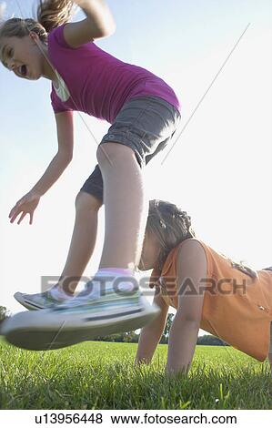 Six and eight year old sisters playing leapfrog, Winnipeg, Canada View Large Photo Image Stock Photo - Six and eight year old sisters playing leapfrog, Winnipeg, Canada. Fotosearch