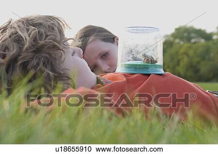 Six year old boy and 8 year old girl, laying on grass with frog in collecting jar, Winnipeg, Canada View Large Photo Image Stock Image - Six year old boy and 8 year old girl, laying on grass with frog in collecting jar, Winnipeg, Canada. Fotosearch
