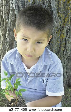 Six year old boy seated beside large tree, Winnipeg, Canada View Large Photo Image Stock Photography - Six year old boy seated beside large tree, Winnipeg, Canada. Fotosearch