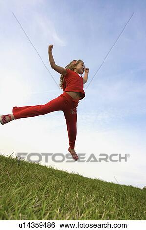 Stock Photograph - Six year old girl jumping, Winnipeg, Canada. Fotosearch