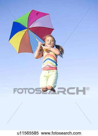 Six year old girl jumping with umbrella, Winnipeg, Canada View Large Photo Image Stock Photography - Six year old girl jumping with umbrella, Winnipeg, Canada. Fotosearch