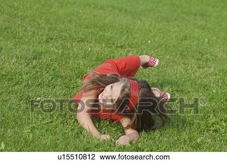 Six year old girl rolling in grass, Winnipeg, Canada View Large Photo Image Stock Image - Six year old girl rolling in grass, Winnipeg, Canada. Fotosearch