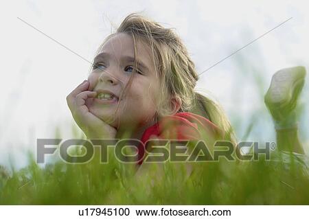 Six year old girl with chin in hands lying on grass, Winnipeg, Canada View Large Photo Image Stock Image - Six year old girl with chin in hands lying on grass, Winnipeg, Canada. Fotosearch