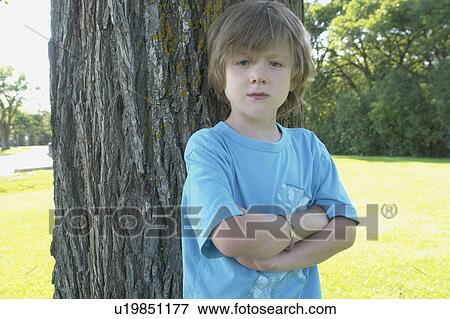 Six year old with arms crossed stands beside tree, Winnipeg, Canada View Large Photo Image Stock Photo - Six year old with arms crossed stands beside tree, Winnipeg, Canada. Fotosearch
