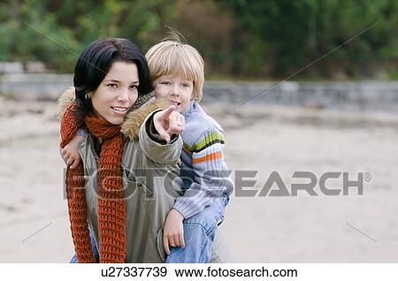 Son looks as mom points out something on the beach, Vancouver, British Columbia View Large Photo Image Stock Photo - Son looks as mom points out something on the beach, Vancouver, British Columbia. Fotosearch