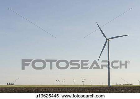 Steel graineries dwarfed by array of wind turbines View Large Photo Image Stock Photography - Steel graineries dwarfed by array of wind turbines. Fotosearch