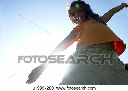 Stock Image - Sunflare, six year old girl with arms outstretched, Winnipeg, Canada. Fotosearch