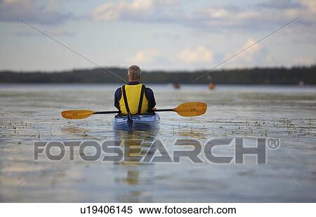 Stock Photography - Taking a moment to enjoy the solitude of a relaxing paddle around the Back Bay portion of the Greay Slave Lake in Yellowknife, Northwest Territories.. Fotosearch