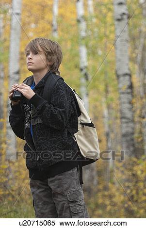 Ten year old boy holding binoculars wearing hemp backpack, Lake Katherine, Riding Mountain National Park, Manitoba View Large Photo Image Stock Photography - Ten year old boy holding binoculars wearing hemp backpack, Lake Katherine, Riding Mountain National Park, Manitoba. Fotosearch