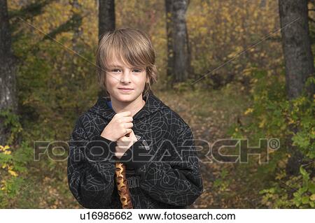 Stock Image - Ten-year-old boy with walking stick on trail in woods, Lake Katherine, Riding Mountain National Park, Manitoba. Fotosearch