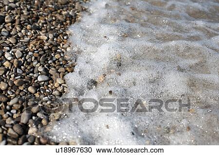 Stock Image - Tide washing over pebbles, Ontario. Fotosearch