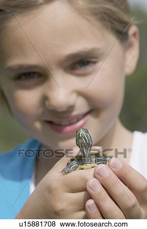 Stock Photo - Turtle held by eight year old girl, Winnipeg, Canada. Fotosearch