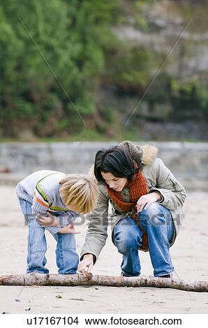 Woman and boy examine objects on beach, Vancouver, British Columbia View Large Photo Image Picture - Woman and boy examine objects on beach, Vancouver, British Columbia. Fotosearch