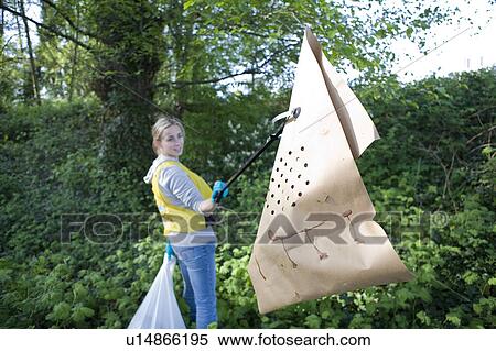 Woman holding up garbage, community clean-up, Vancouver, Canada View Large Photo Image Stock Photography - Woman holding up garbage, community clean-up, Vancouver, Canada. Fotosearch