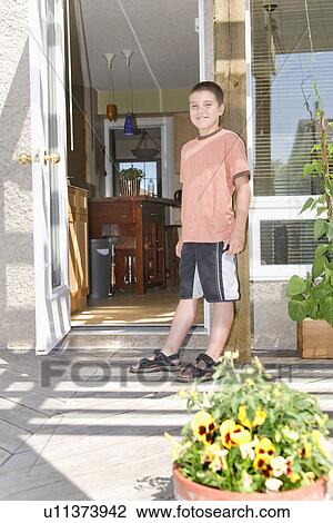 Stock Image - Woman with recycling bin at back door of home, Winnipeg, Canada. Fotosearch