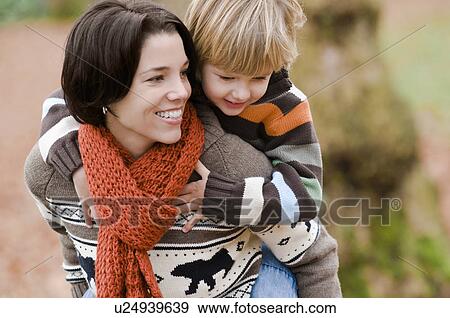 Young boy rides piggy back on woman's back in autumn, Vancouver, British Columbia View Large Photo Image Stock Photo - Young boy rides piggy back on woman's back in autumn, Vancouver, British Columbia. Fotosearch