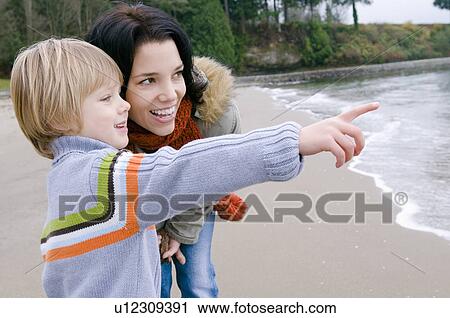 Young boy with mother points toward ocean, Vancouver, British Columbia View Large Photo Image Stock Image - Young boy with mother points toward ocean, Vancouver, British Columbia. Fotosearch