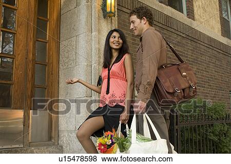 Young couple carrying groceries in cloth bags at entrance of apartment building, Winnipeg, Canada View Large Photo Image Stock Photo - Young couple carrying groceries in cloth bags at entrance of apartment building, Winnipeg, Canada. Fotosearch