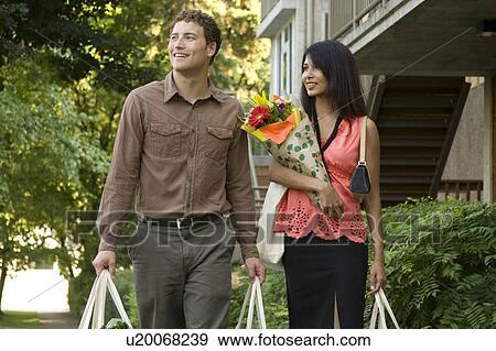 Young couple carrying groceries in cloth bags, Winnipeg, Canada View Large Photo Image Stock Photo - Young couple carrying groceries in cloth bags, Winnipeg, Canada. Fotosearch