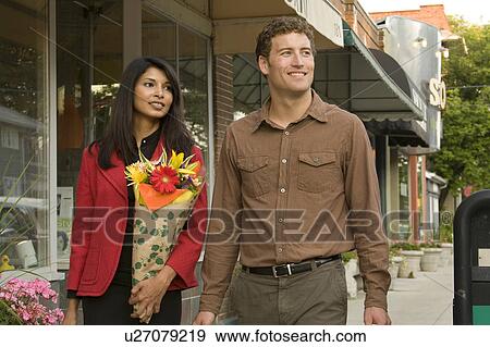 Stock Photo - Young couple carrying groceries in cloth bags at shop window, Winnipeg, Canada. Fotosearch