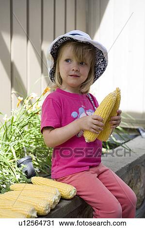 Young girl holding peeled ears of corn, Saskatchewan, Canada View Large Photo Image Stock Image - Young girl holding peeled ears of corn, Saskatchewan, Canada. Fotosearch